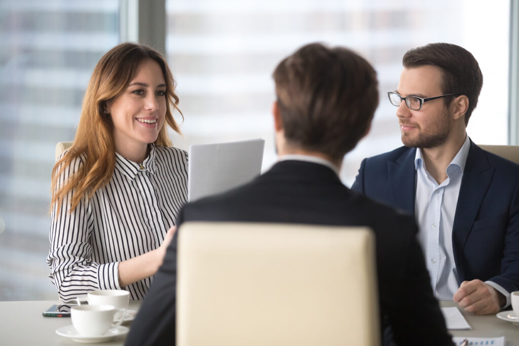 Young broker businesswoman discussing with two other businessmen how to maintain broker dealer compliance