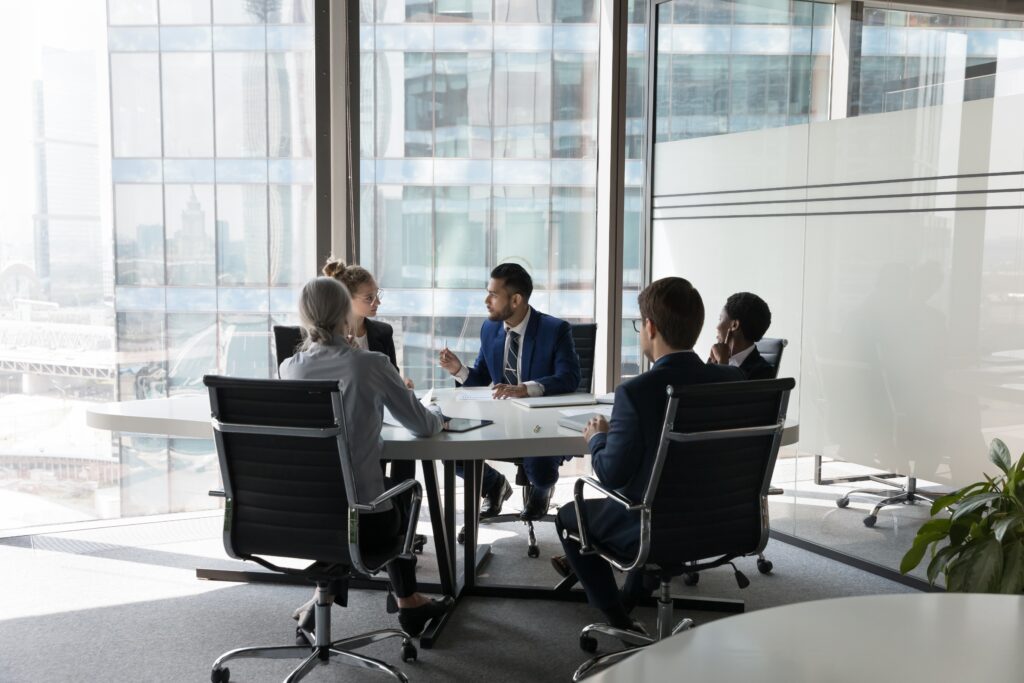 A group of accountants at a table in their office discussing a current engagement and pcaob accounting rules