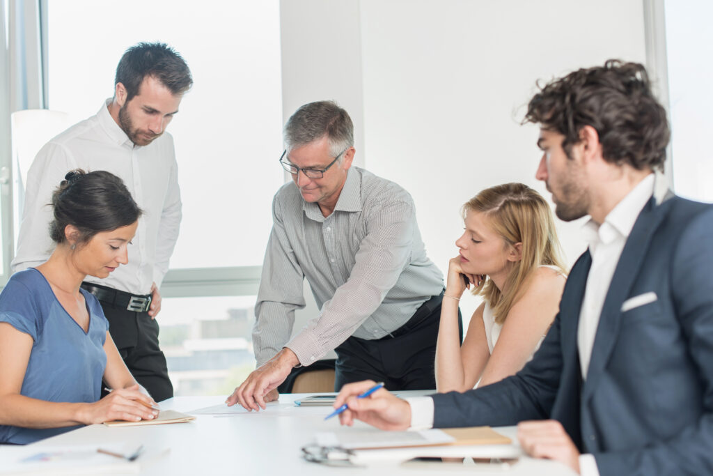 A group of people in an office conference room reviewing new pcaob auditing standards