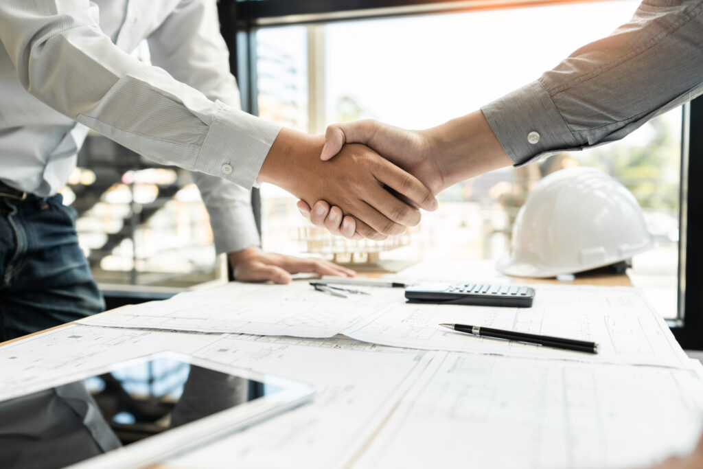 A man from a construction CPA firm shaking hands with a contractor in their office 