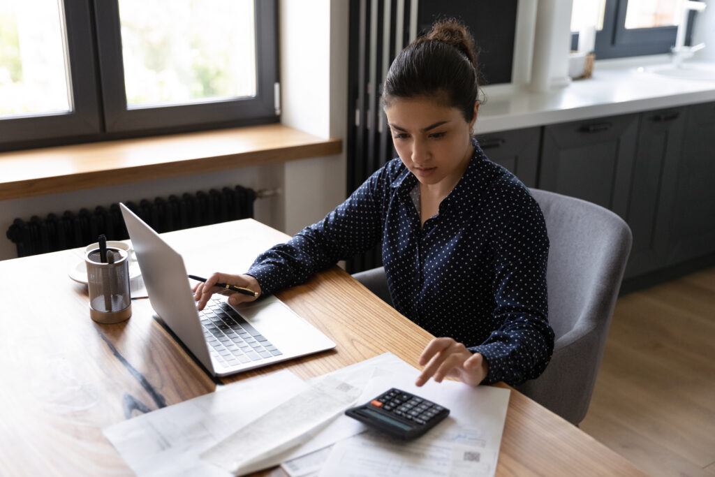 A woman who is an accountant reviewing documents on her laptop for a custody audit engagement