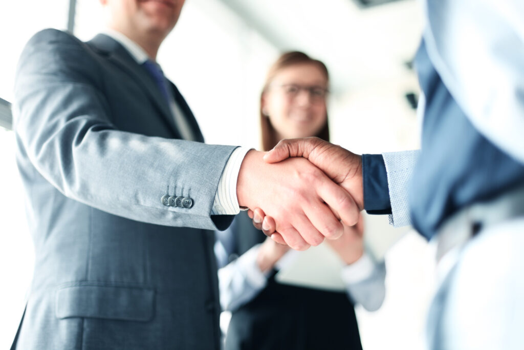 A comany shaking the hand of an accounting at an audit firm after selecting to work with that firm