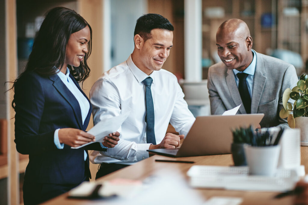 Smiling group of diverse CPA auditors reviewing paperwork for benefit plan audits