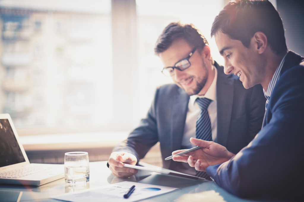 Two young audit professionals using a touchpad to review documents in PCAOB audits