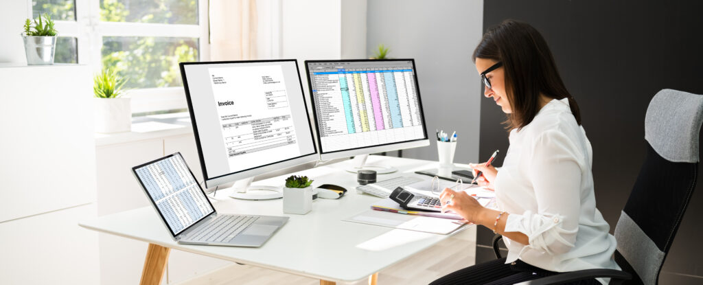 Woman sitting at a computer reviewing surprise audit documents