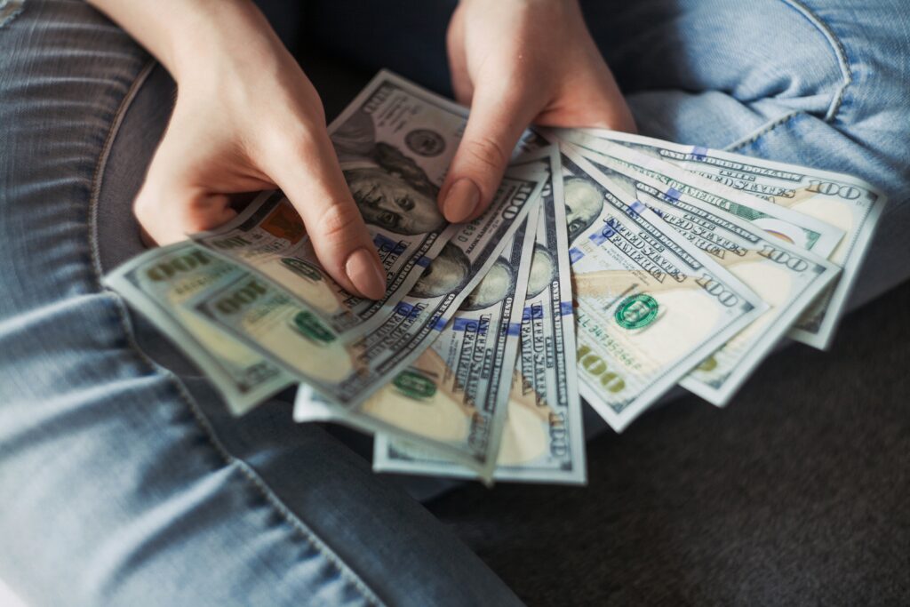 A woman holding donation money to track in preparation of the nonprofit's uniform guidance audit