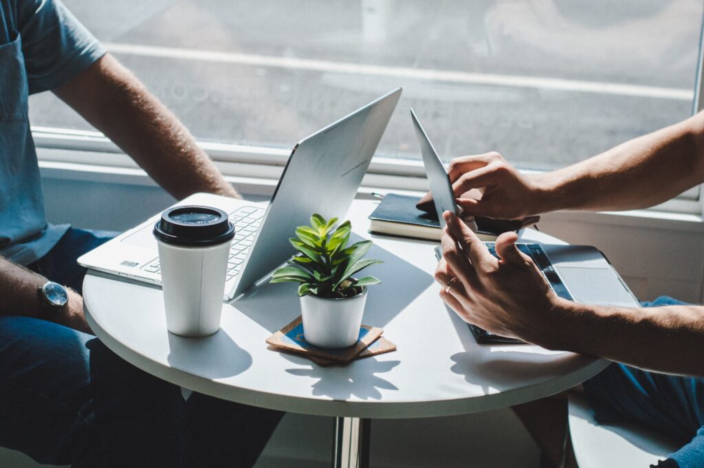 Two accountants reading FINRA compliance rules on laptops at a table