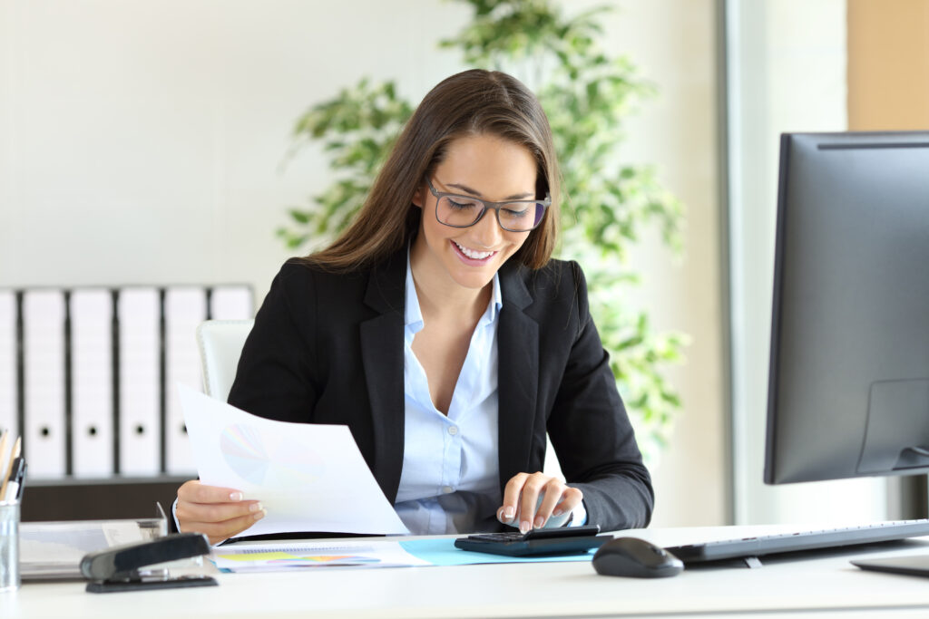 A woman who is a PCAOB auditor reviewing documents from a client