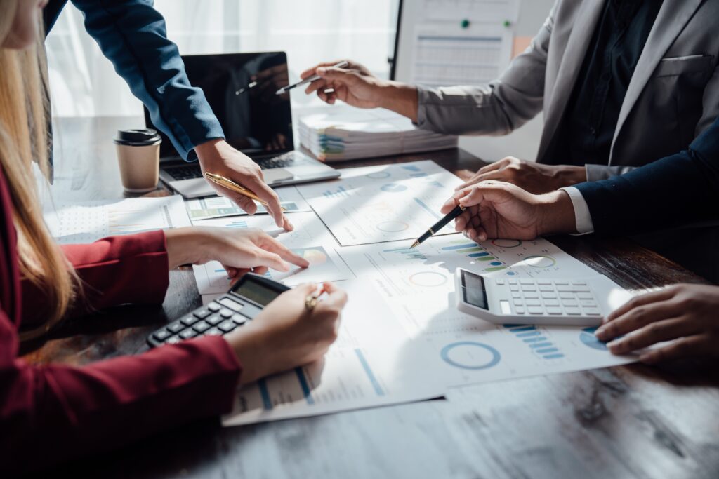 A meeting of an accountants at a certified public accounting firm reviewing documents on a large table