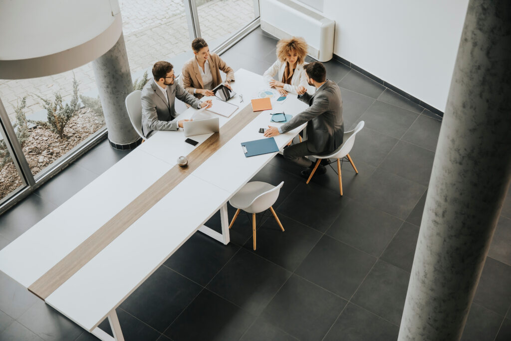 An overhead view of a group of nonprofit auditors meeting at an organization's headquarters