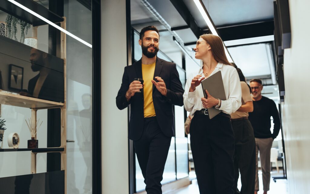 Two professionals at an accounting firm walking down the hall discussing guidance updates to financial statement assertions