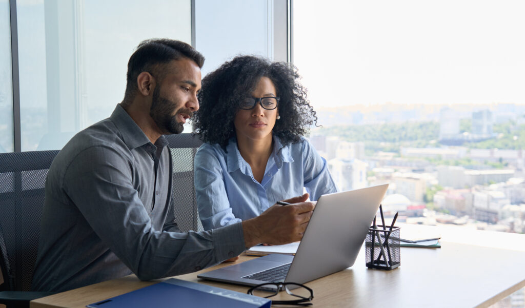 A woman and a man reviewing benefit plan documents to determine if their plan needs a form 5500 audit