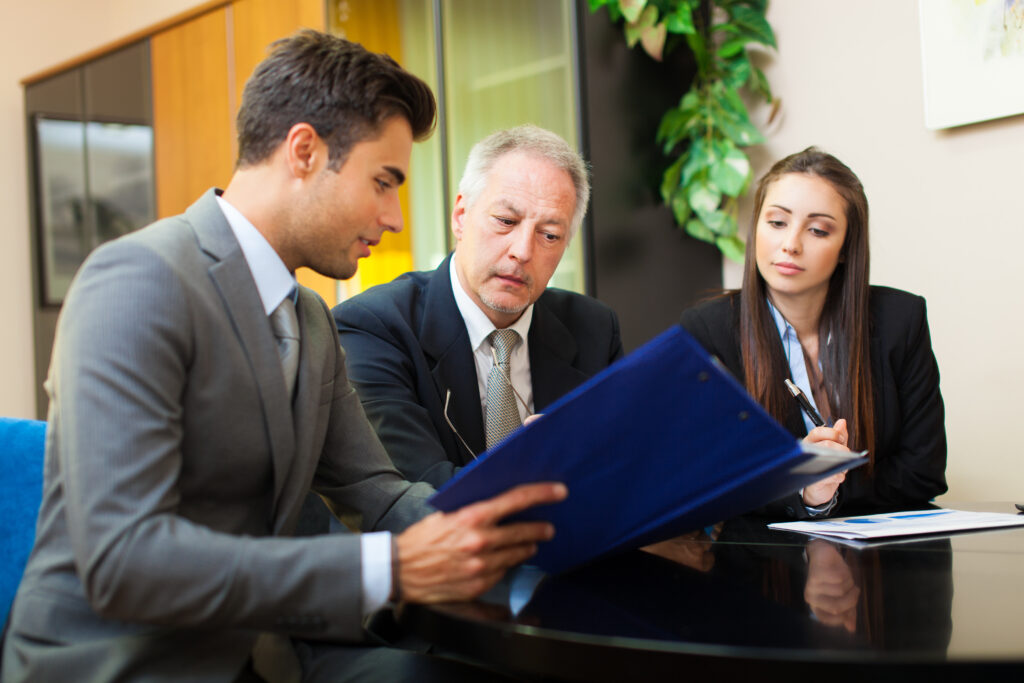 A male CPA from a registered public accounting firm reviewing documents with clients