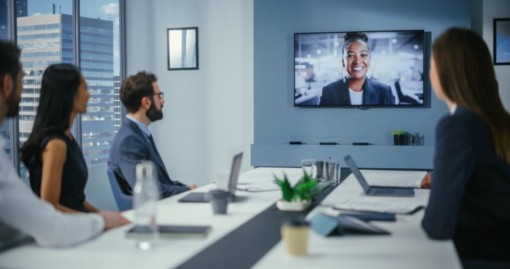 People in a conference room talking to their auditor on the screen during their remote audit