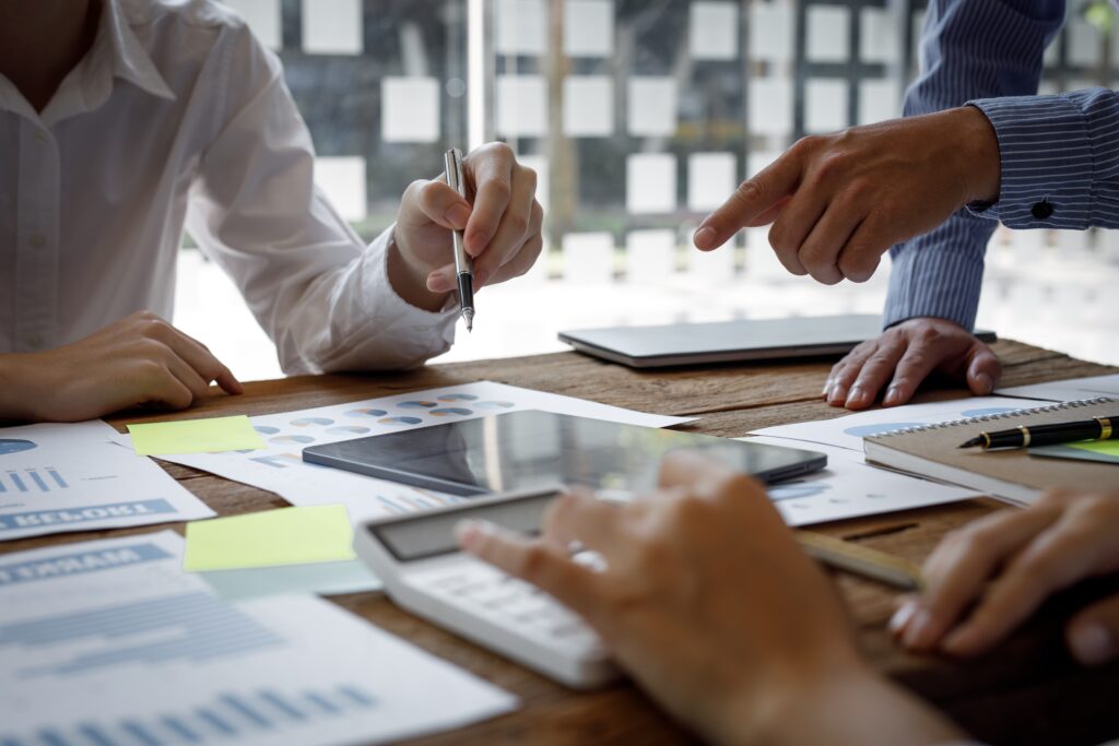 A group of accountants reviewing updated regulations for an SEC audit of a company