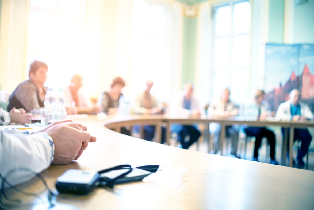 A nonprofit board of directors sitting around a table listening to the results of their recent federal single audit