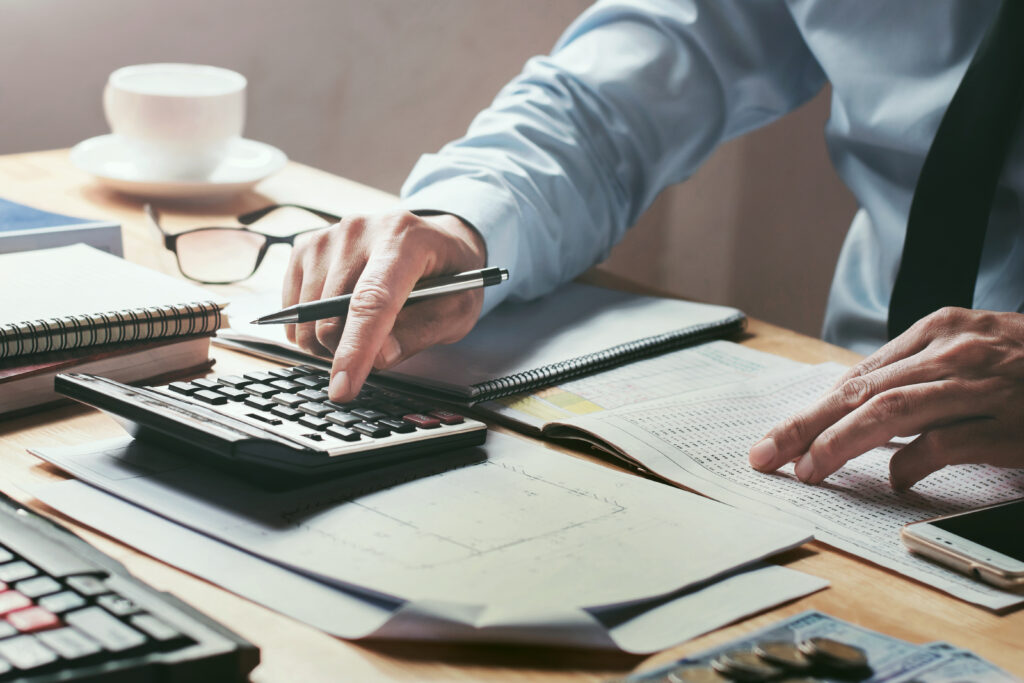 An accountant working on compilation and review engagements at a desk with paperwork and a calculator