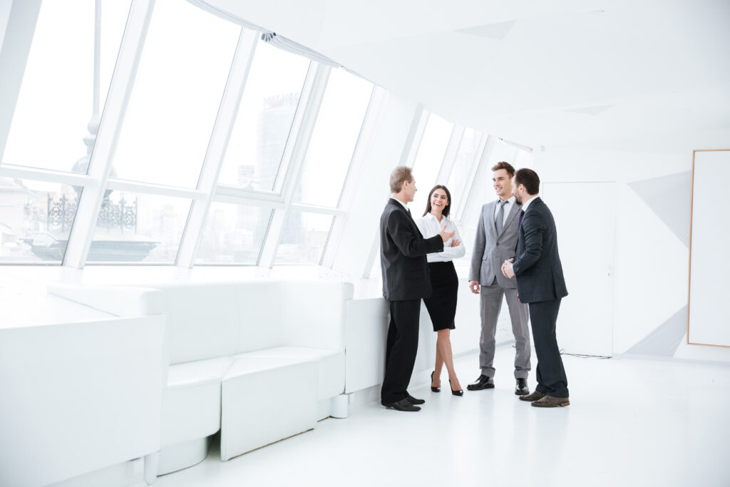 A group of accountants in a hallway talking about changes to single audit requirements for nonprofits