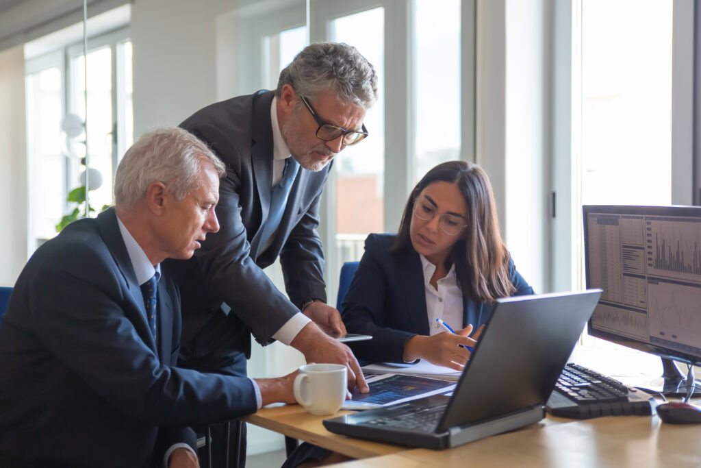 A male accountant explaining the custody rule exemption to a male and woman coworker seated at desk