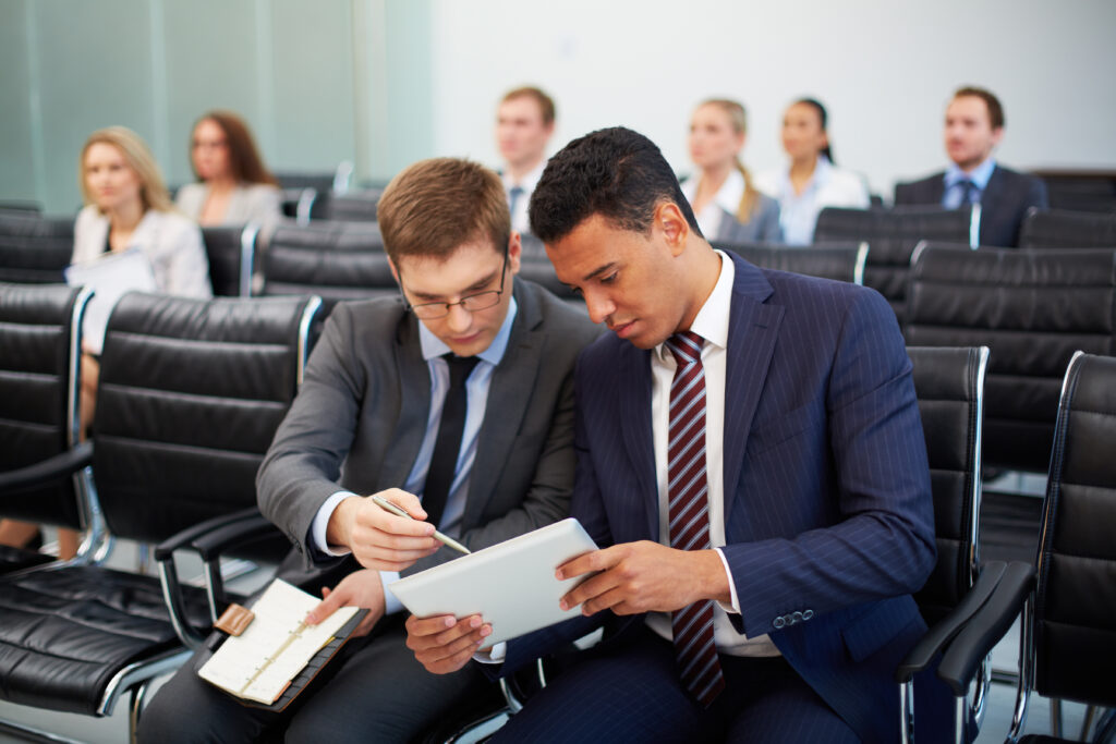 Two young registered investment advisors discussing new information related to an upcoming custody rule audit