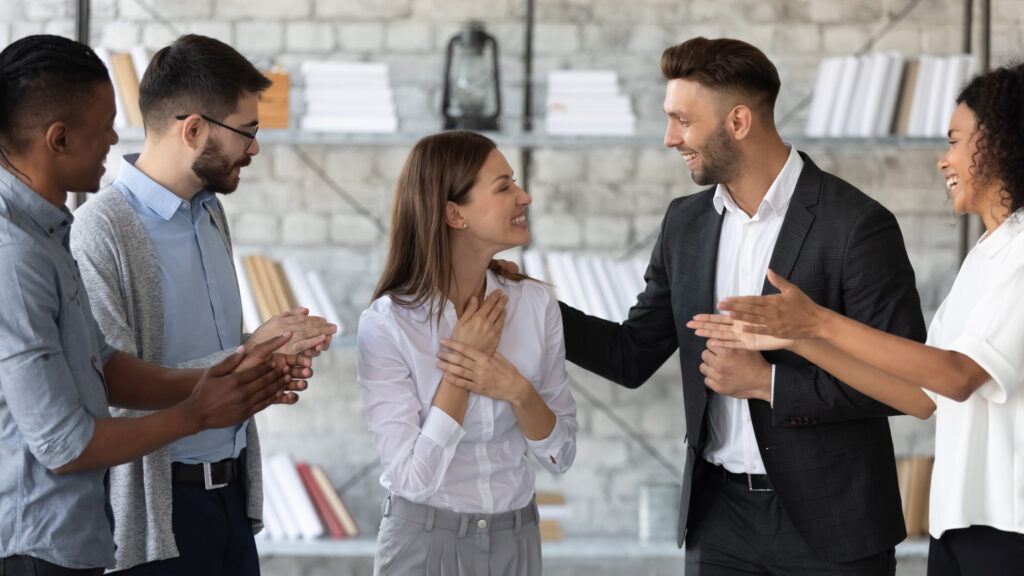 A group of professionals showcasing a great accounting firm culture by congratulating a woman accountant in their firm