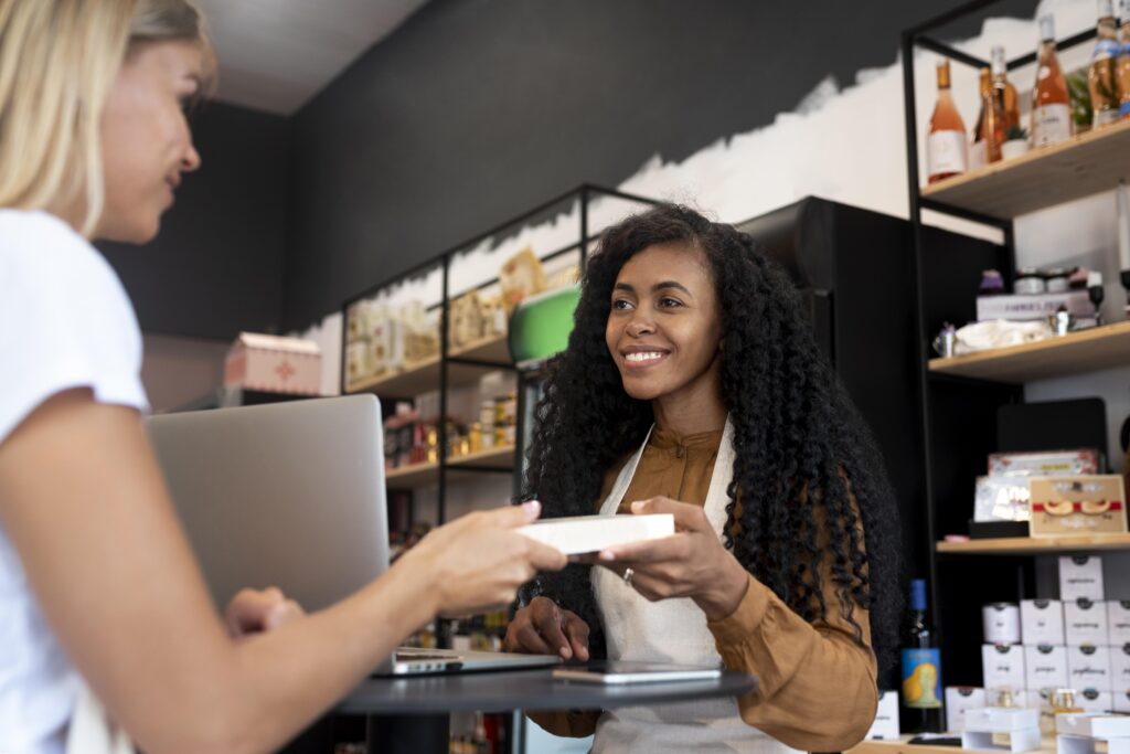 Smiling cashier assisting a customer in a retail store, highlighting franchise accounting services for accurate financial management.