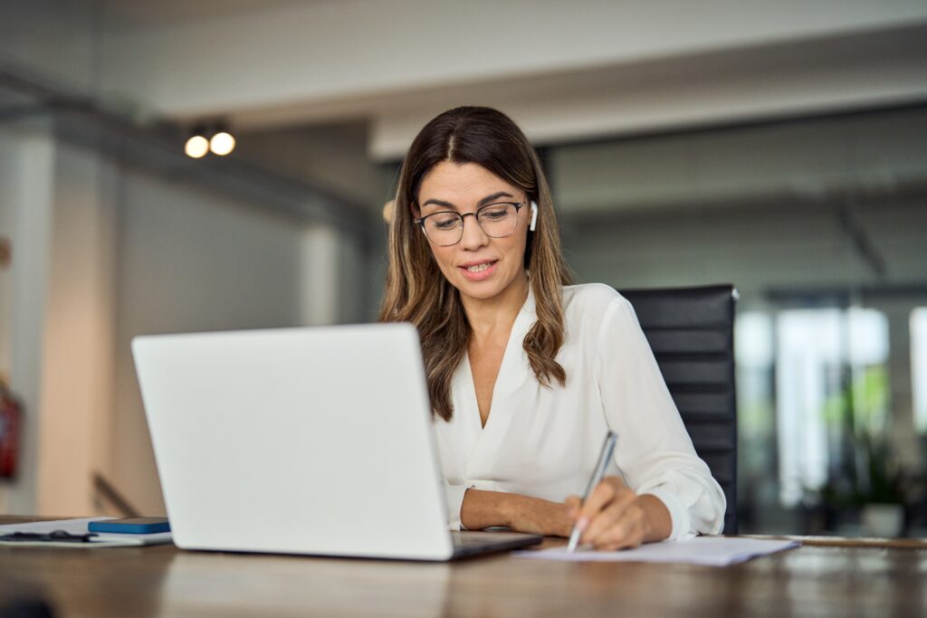 A female virtual auditor who is on a call on her laptop with her clients while reviewing financial statements