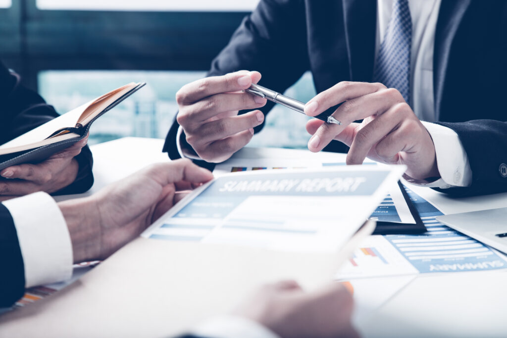 Close-up of a business meeting discussing reviewed financial statements and summary reports.