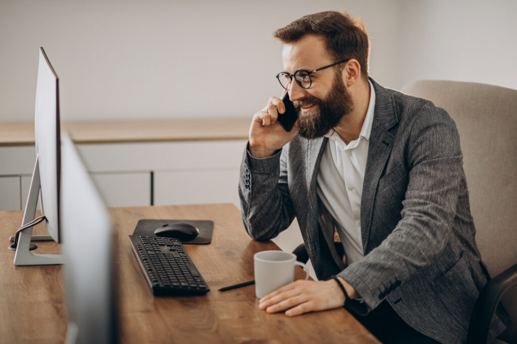 Office professional on the phone, connecting with clients about review engagements for accurate financial reporting.