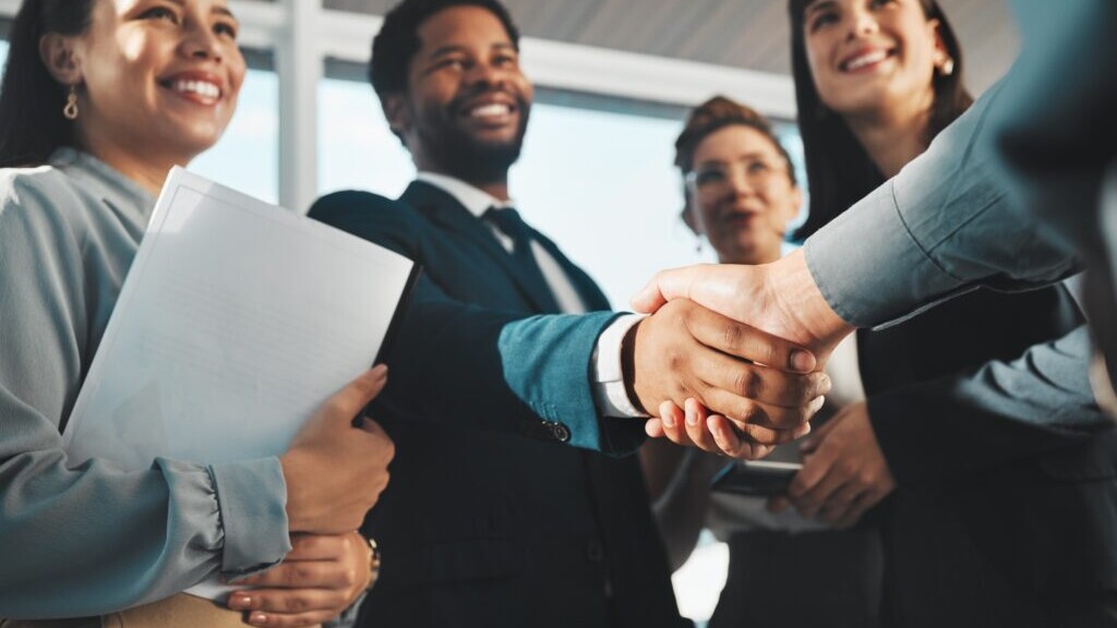 Team members shaking hands, representing a supportive accounting firm culture focused on respect, collaboration, and growth.