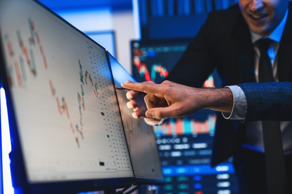 Professionals reviewing stock performance on a screen, emphasizing the role of PCAOB accounting in equity and liability classification