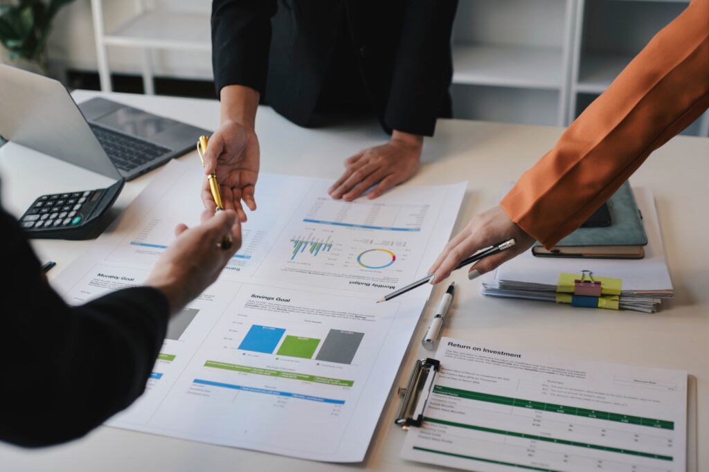 Business professionals reviewing charts and data, highlighting complex debt instruments during a public accounting audit.