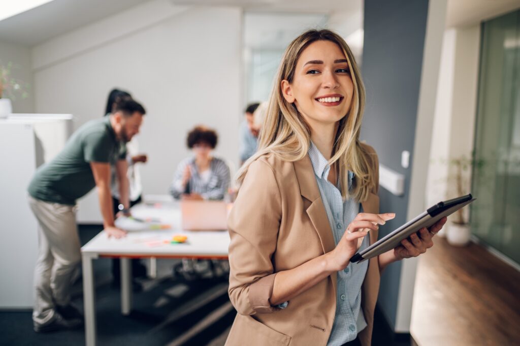 Smiling professional with tablet, representing efficient accounting and outsourcing services for business growth and support.