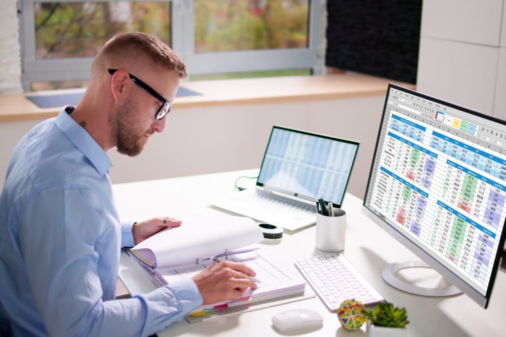 Professional reviewing financial data on multiple screens, illustrating audit readiness services for compliance.