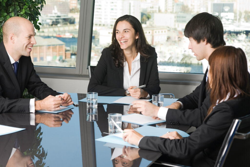 Broker dealers at a meeting discussing the top broker dealer audit firms and strategies for selecting the best firm.