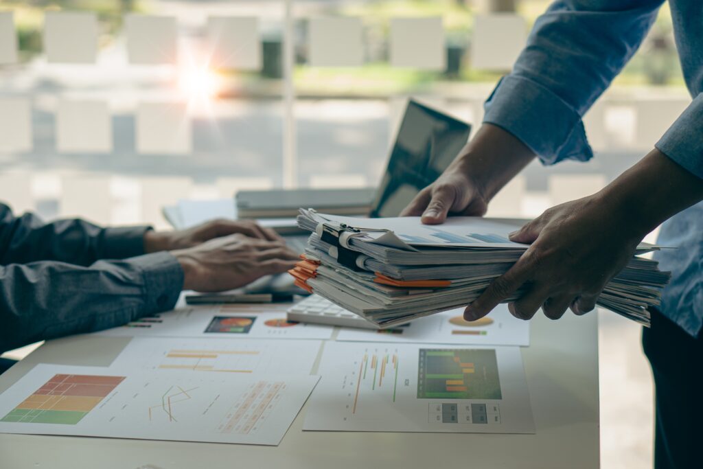 Employee reviewing paperwork and deadlines for their company's FINRA annual audit and reading details on filing extensions.