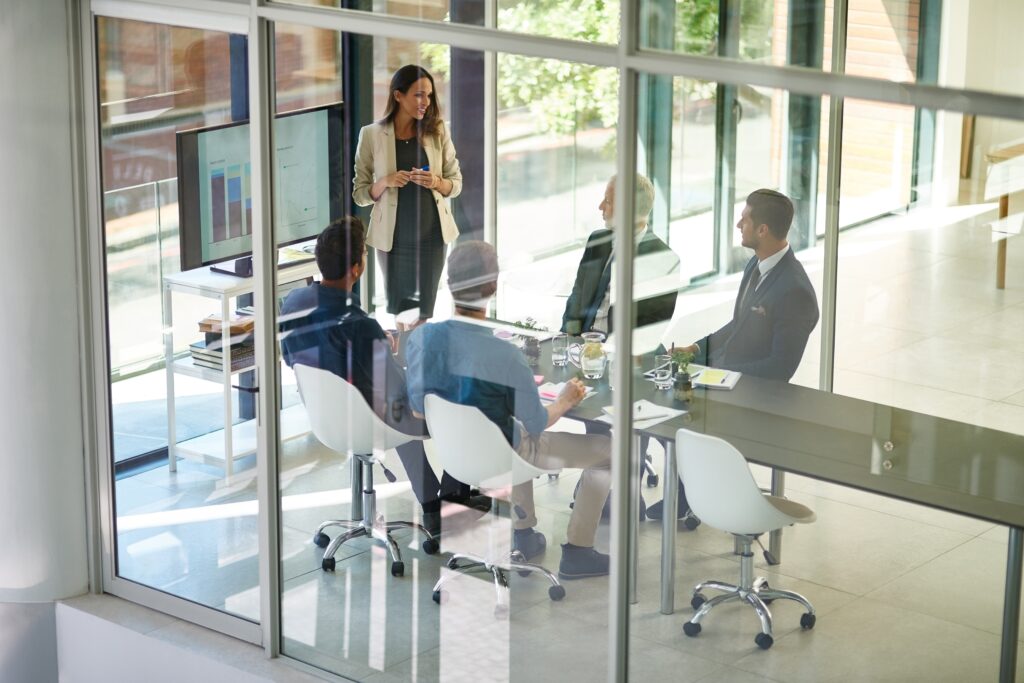 Businesswoman in a conference room discussing compliance and financial strategies provided by top 401k audit firms.