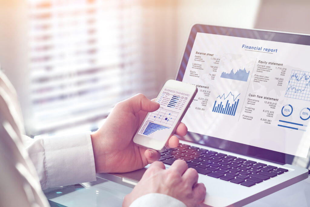 A financial professional preparing an audited financial statement on a laptop to meet regulatory and reporting standards.