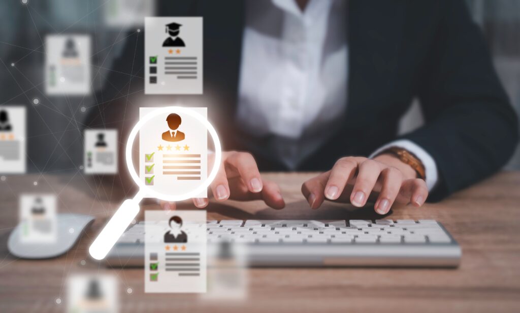 Close-up of hands typing with floating resumes, representing digital systems used to administer 401k plan participant data.