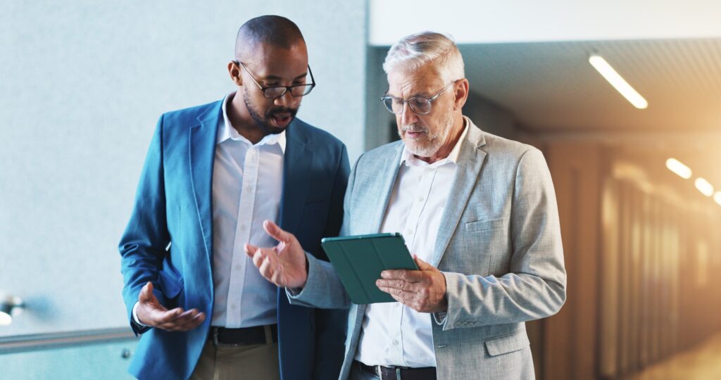 Top financial preparation services discussed by two professionals reviewing a tablet in an office.