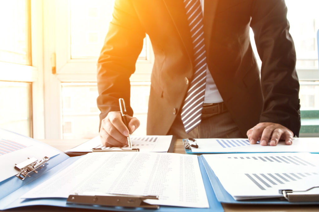 US GAAP audit paperwork reviewed on clipboards with financial charts and report pages.