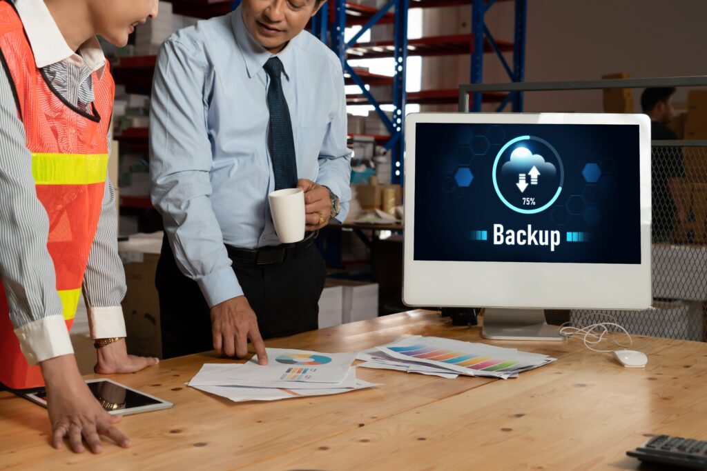 Cyber attack IT Risk Assessment planning with a backup dashboard and printed charts on a worktable.