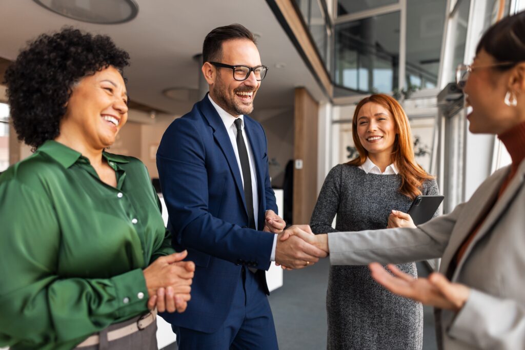 Team members shake hands in an office while discussing an outsourced accounting partner relationship.