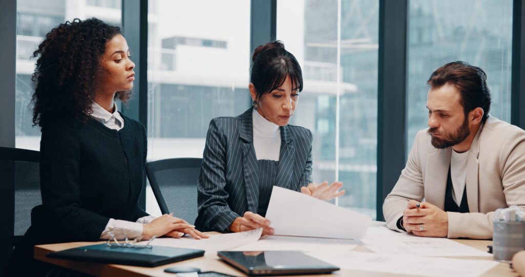 SEC 17a4 compliance discussion with professionals reviewing papers in a meeting room.