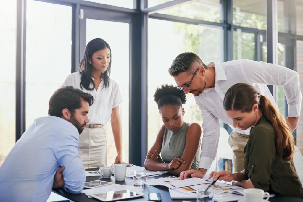 Uniform guidance single audit preparation brings a team together to review reports and charts.