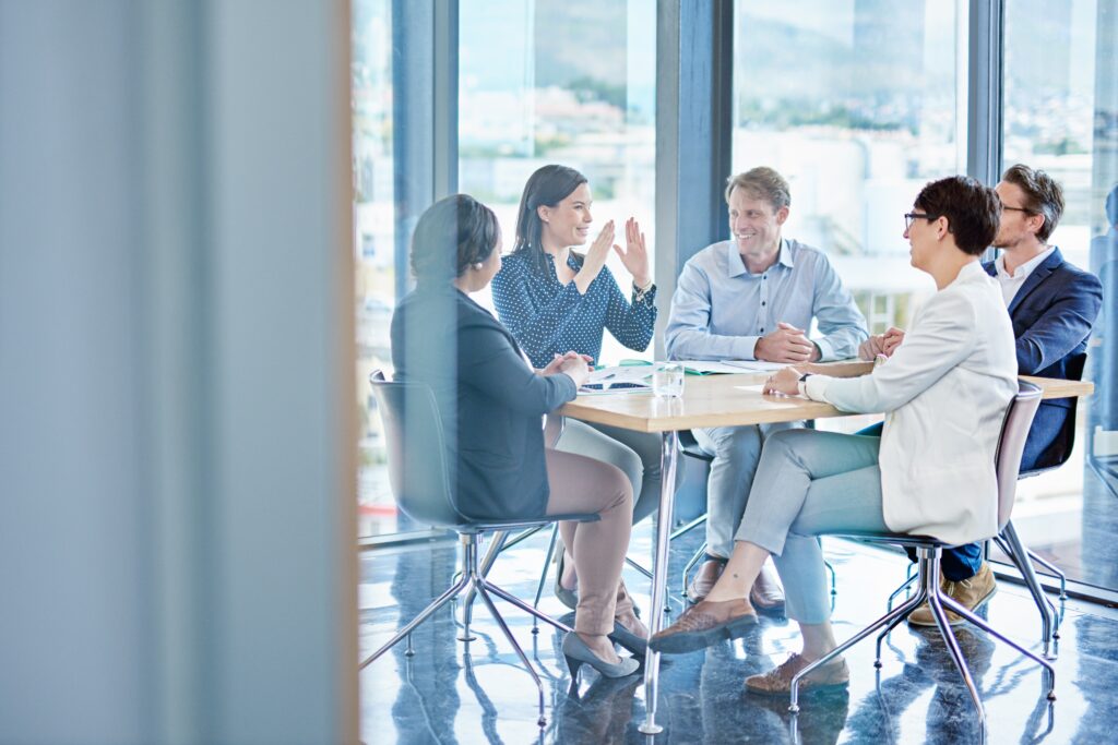 Uniform guidance single audit preparation brings a team together to review documents in a conference room.